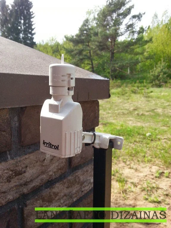 Laistymo sistemos lietaus jutiklis „Irritrol“, pritvirtintas prie tvoros stulpelio